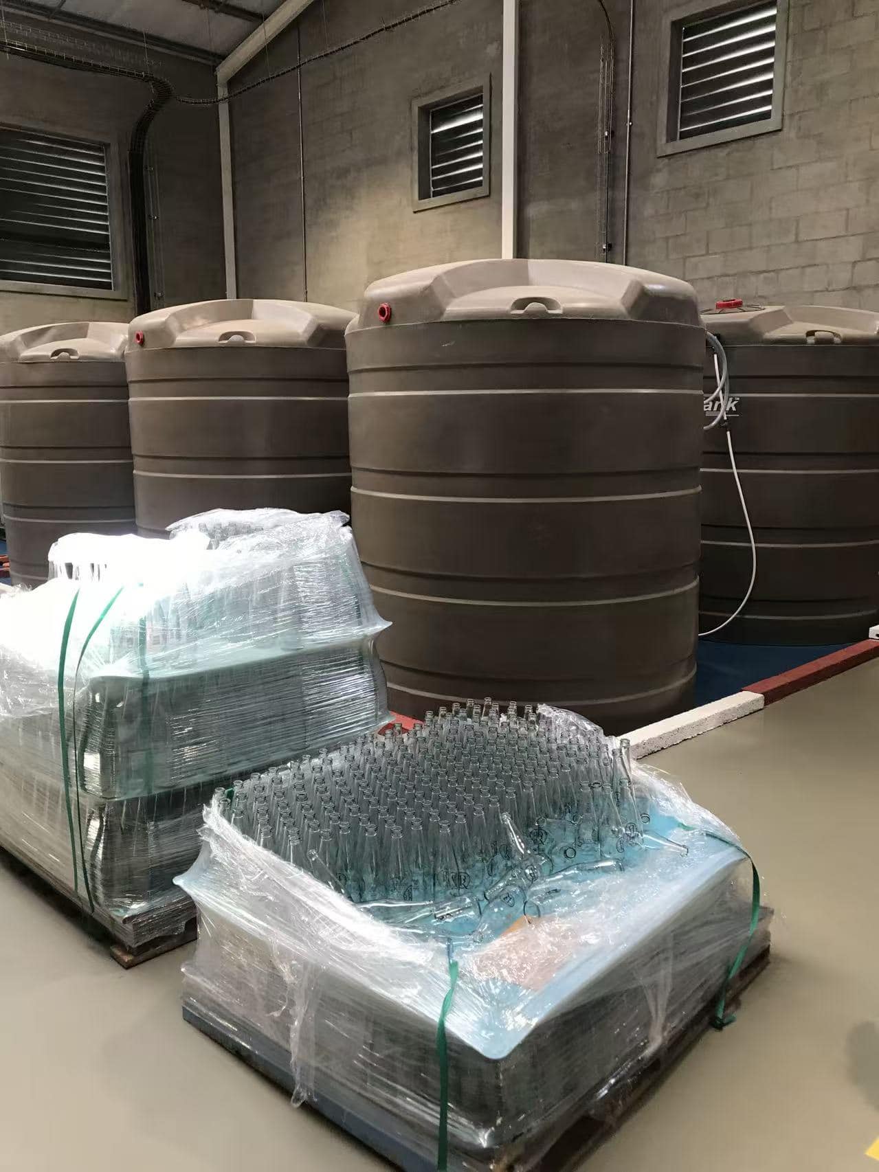 Lagertanks und palettierte Glasflaschen in einer Abfüllanlage